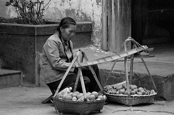 Woman with baskets, China